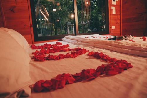a bunch of red roses laying on a bed at Căn Bighomie in Sóc Sơn