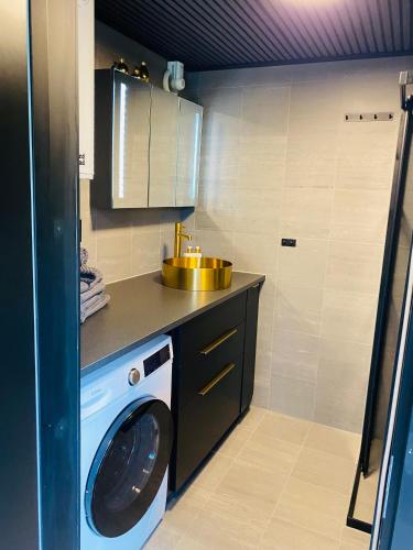 a kitchen with a washing machine and a sink at Färlevfjordens Glamping Brastad in Brastad