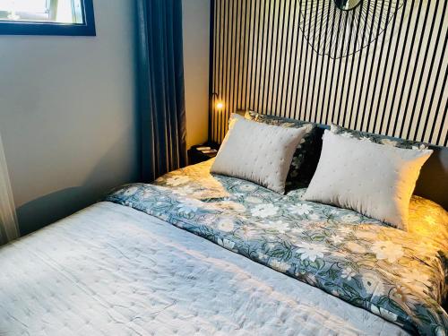 a bedroom with a bed with pillows on it at Färlevfjordens Glamping Brastad in Brastad
