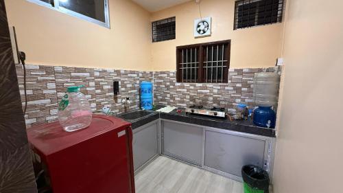 Una pequeña cocina con encimera y refrigerador rojo. en The Aurelia Inn, en Sibsāgar