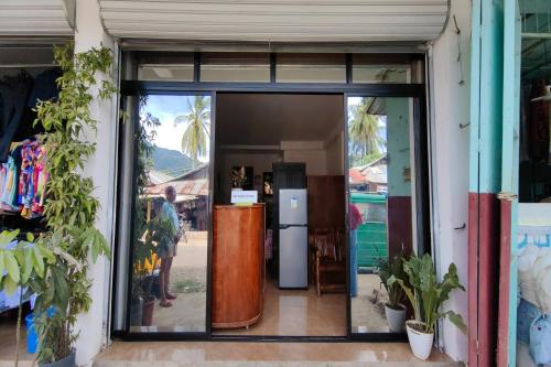 a glass door of a store with a refrigerator at Kamalay Pension House in Nagpoyopoyo Island