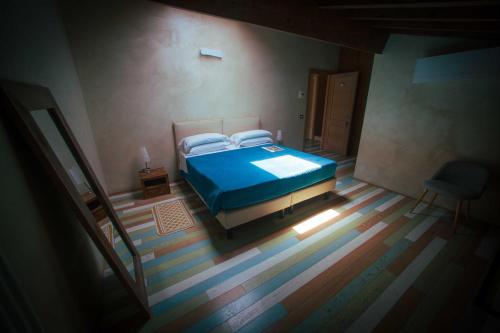 a bedroom with a blue bed and a chair at Casale Elisa Country Hotel in Ladispoli
