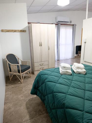 a bedroom with a green bed and a chair at Cruz del Sur in Santa Rosa
