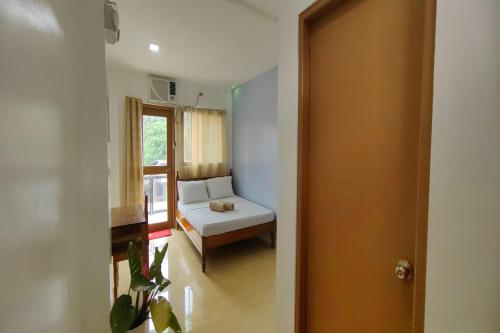 a small room with a bed and a window at Kamalay Pension House in Nagpoyopoyo Island