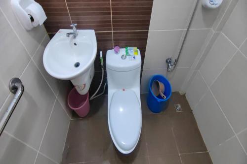 a bathroom with a toilet and a sink at Kamalay Pension House in Nagpoyopoyo Island