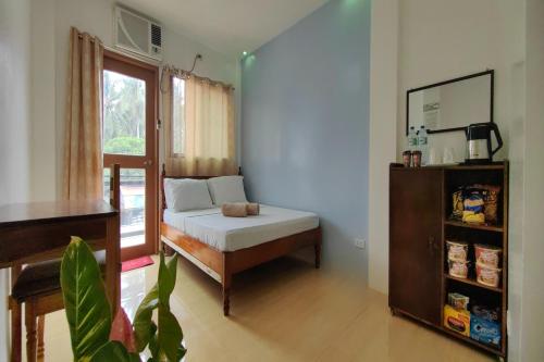a bedroom with a bed and a window at Kamalay Pension House in Nagpoyopoyo Island