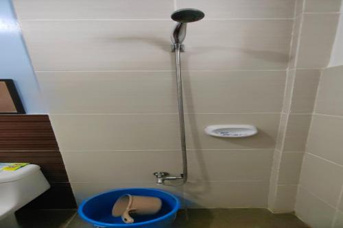 a bathroom with a shower with a sandal in a bucket at Kamalay Pension House in Nagpoyopoyo Island