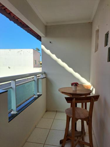 a small table and stool in a room with a window at Apartamento Dúplex em Flecheiras in Trairi
