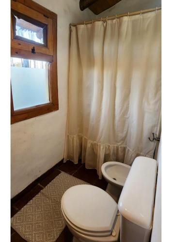 Un baño con inodoro, lavabo y ventana. en Serena Cumbre Lodge, en San Rafael