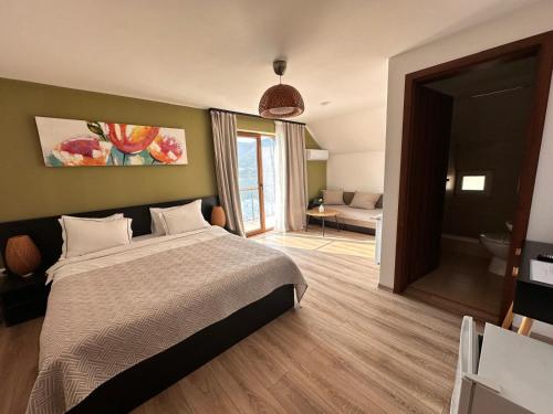a bedroom with a large bed and a bathroom at Casa Dani in Colibiţa