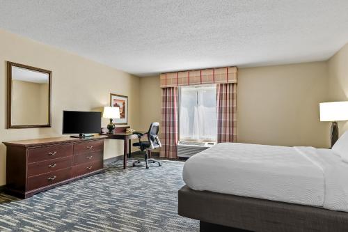 a hotel room with a bed and a desk with a computer at Country Inn & Suites by Radisson, Princeton, WV in Princeton
