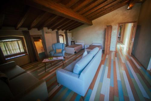 a living room with a blue couch and a bed at Casale Elisa Country Hotel in Ladispoli