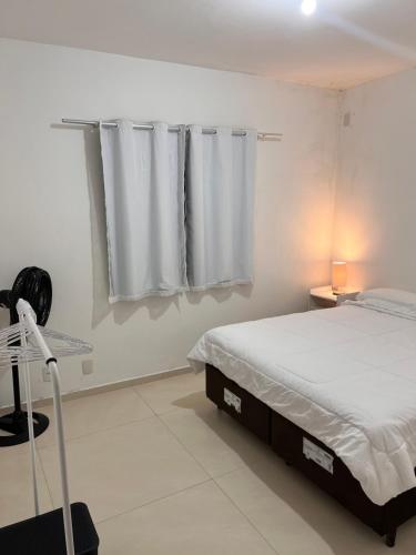 a white bedroom with a bed and a window at Apartamento próx ao CTG e Arena Opus São José in São José