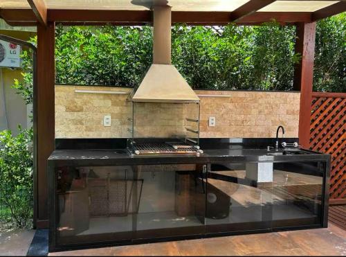 eine Außenküche mit Herd und Spüle in der Unterkunft Melhor casa Praia na Reserva do Sahy in Mangaratiba