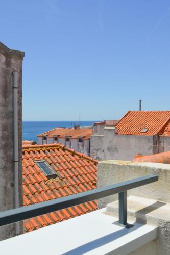 a view from the balcony of a building with orange roofs at Casa Luminosa - 160m to the beach, located in the Historical Center of Sesimbra in Sesimbra