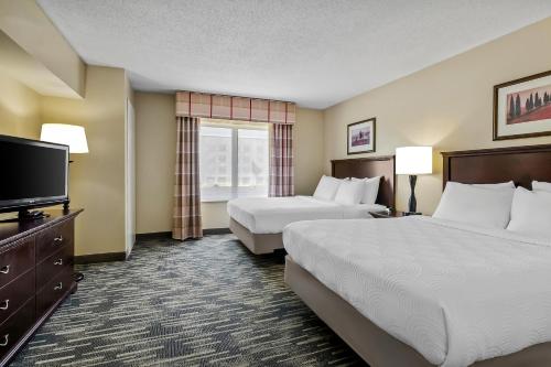 a hotel room with two beds and a flat screen tv at Country Inn & Suites by Radisson, Princeton, WV in Princeton