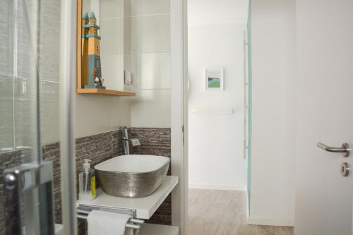 a bathroom with a sink and a toilet in it at Casa Luminosa - 160m to the beach, located in the Historical Center of Sesimbra in Sesimbra