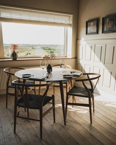 a dining room with a table and chairs and a window at Nymindegab Kro in Nørre Nebel