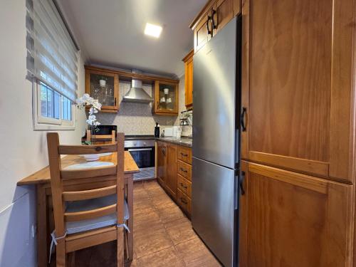 a kitchen with a stainless steel refrigerator and wooden cabinets at La Planta Vieja III in La Orotava