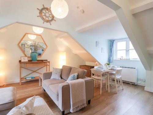 a living room with a couch and a table at Smugglers Loft in Looe