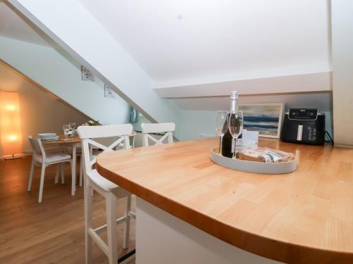 a kitchen with a counter with wine glasses on it at Smugglers Loft in Looe