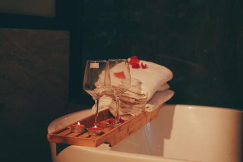 two wine glasses sitting on top of a bath tub at Căn Gỗ in Sóc Sơn