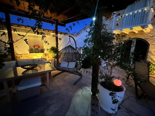 a patio at night with a swing and a tree at Little Stone House in Lymbia