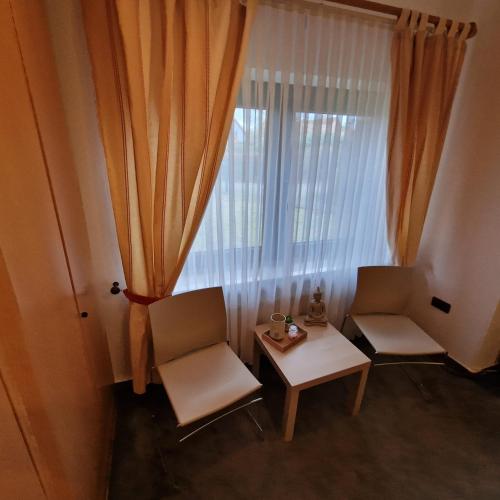 a room with two chairs and a table and a window at BoardingHouse Neerstedt in Dötlingen