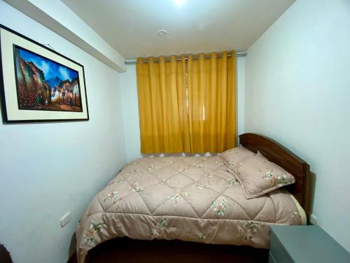 a bedroom with a bed and a window with a curtain at Marlen's Qorywasi in Cusco