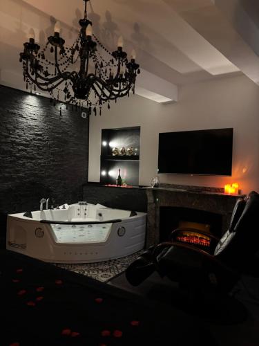 a living room with a bath tub and a tv at Love Room L'instanté - Suite "L'élégante" in Limoux