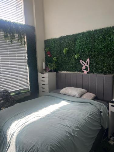 a bedroom with a bed with a green wall at Luxury Apartment UConn in Storrs