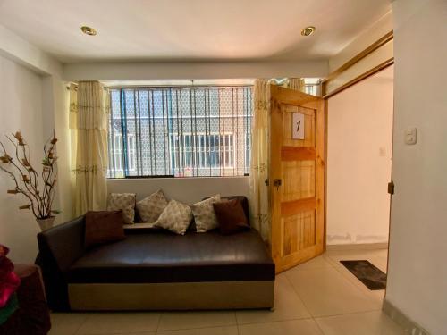 a living room with a couch and a window at Marlen's Qorywasi in Cusco
