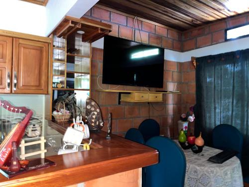 a kitchen with a tv on a brick wall at Villa Mercedes in La Dorada