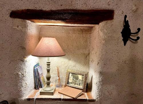 a table with a lamp and a picture of a cat on it at Le Boudoir de Zine, une escapade au cœur des châteaux in Vallères