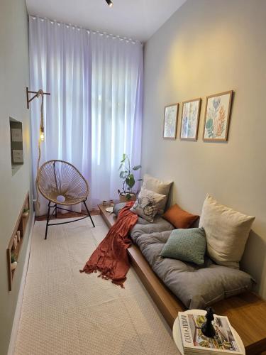 a living room with a couch in front of a window at Seu Loft em BH, conforto e localização perfeita in Belo Horizonte