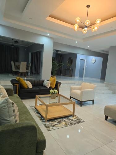 a living room with couches and a coffee table at Stegor Suites in Maun