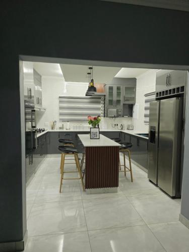a kitchen with stainless steel appliances and a table with chairs at Stegor Suites in Maun