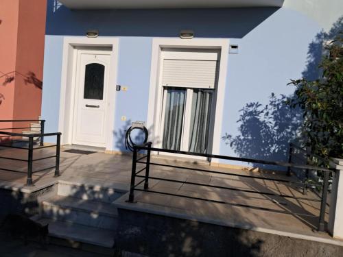 a front porch of a house with a white door at Liberty Cozy Apartment in Kalloni