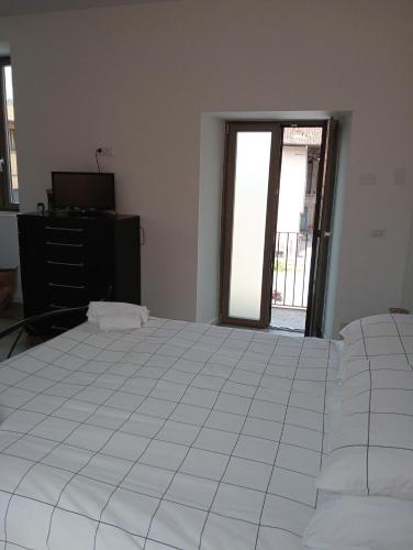 a bedroom with a white bed and a dresser and a window at Vi & Vi relax by the lake in Montorfano