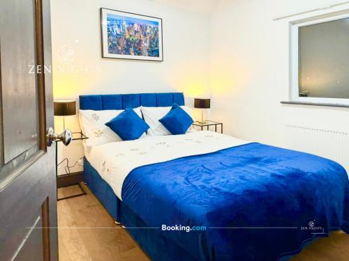 a bedroom with a blue and white bed with blue pillows at Last-minute Specials l Elegant House near City Center Sleeps 8 with Free Parking l Near DeMontfort Uni l By Zen Nights Short Lets & Serviced Accommodations in Leicester