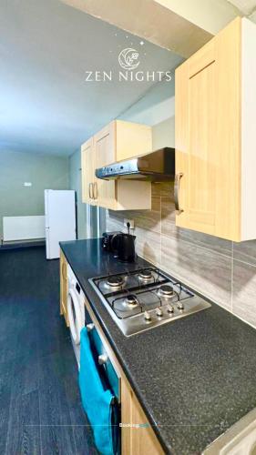 a kitchen with a stove top oven in a room at Last-minute Specials l Elegant House near City Center Sleeps 8 with Free Parking l Near DeMontfort Uni l By Zen Nights Short Lets & Serviced Accommodations in Leicester