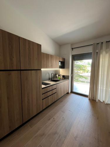 a kitchen with wooden cabinets and a large window at YUGOGO PETRARCA 1 - Trilocale con balcone in Trento