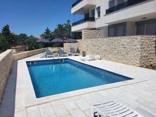a swimming pool in front of a house at Apartment Mare D with a pool new in Novalja