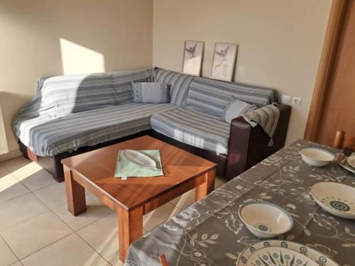 a living room with a couch and a table at Liberty Cozy Apartment in Kalloni