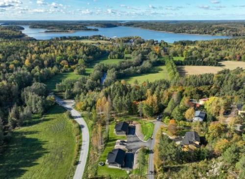 an aerial view of a house with a road and a lake at Kiiski Home in Teijo
