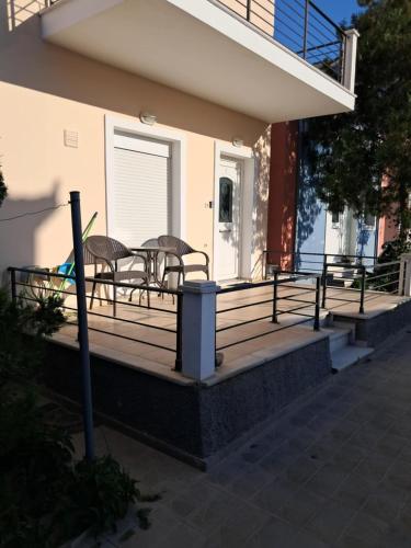 a porch of a house with two chairs and a table at Liberty Cozy Apartment in Kalloni