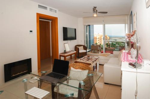 salon z laptopem na szklanym stole w obiekcie Apartamento Deluxe: hidromasaje, terraza y vistas. w mieście Las Hortichuelas