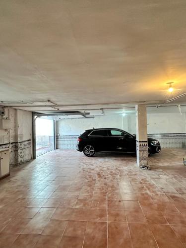 a parking garage with a car parked in it at Can Guzmu in Cijuela