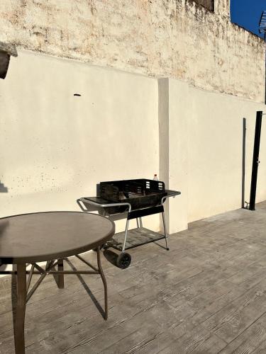 a table and a grill in a room at Can Guzmu in Cijuela