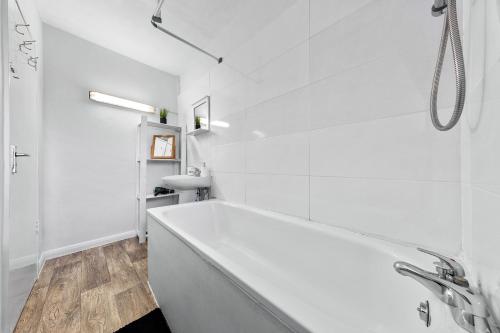 a white bathroom with a tub and a sink at South Stays 3 in London